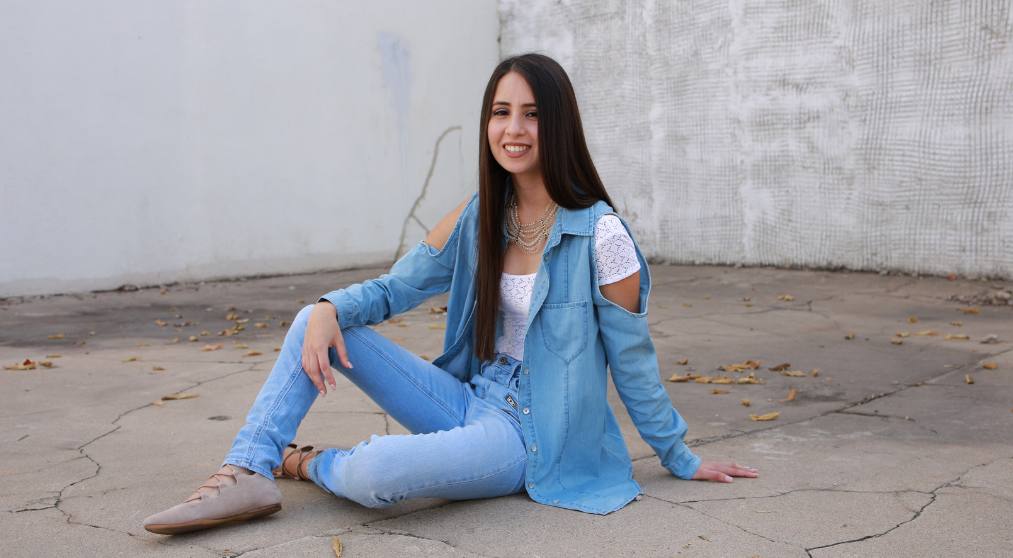 Woman sitting on the ground and smiling.