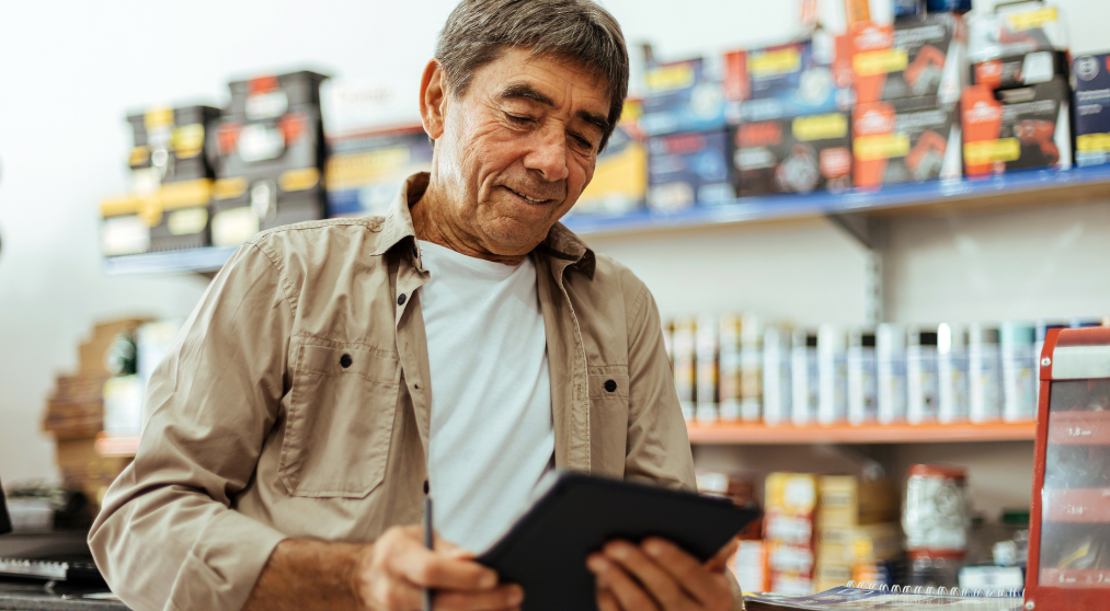 hispanic male small business owner looking at tablet