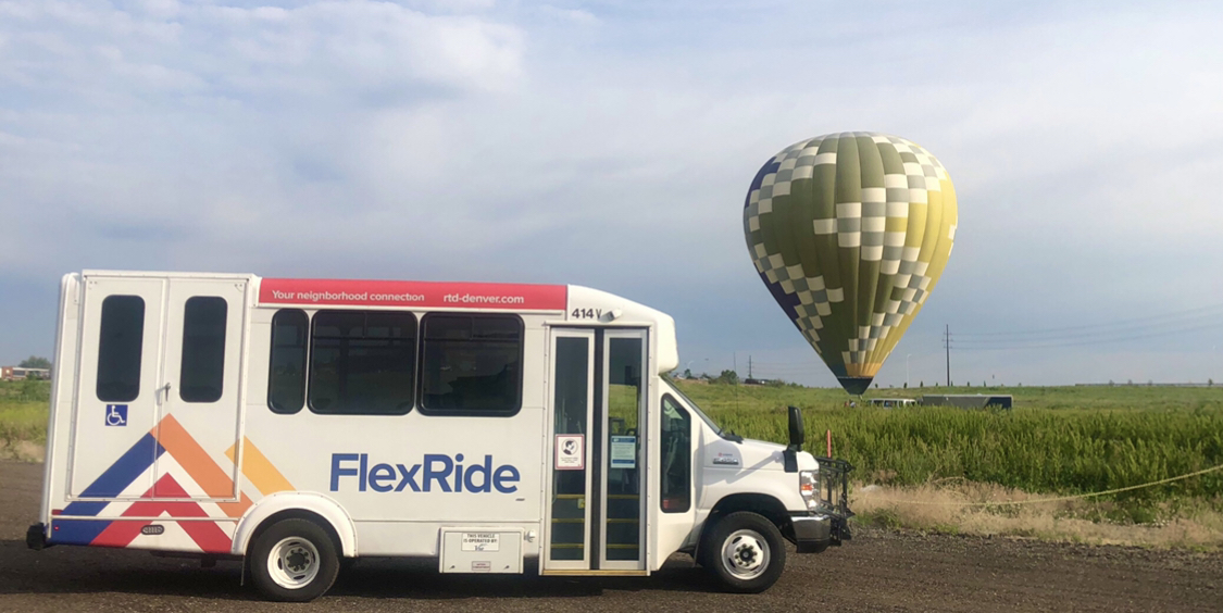 Public bus parked near a hot air balloon