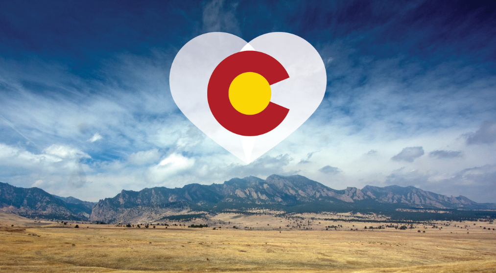 the Colorado "C" wrapped in a white heart that is displayed over a view of the front range
