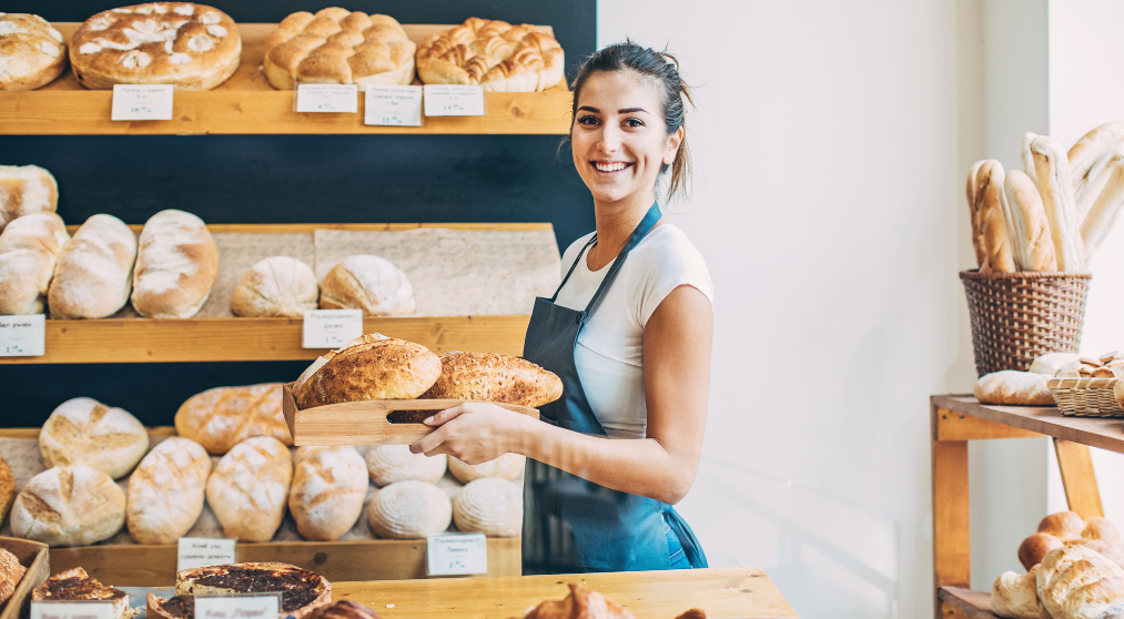 Woman holding bread in the bakery.