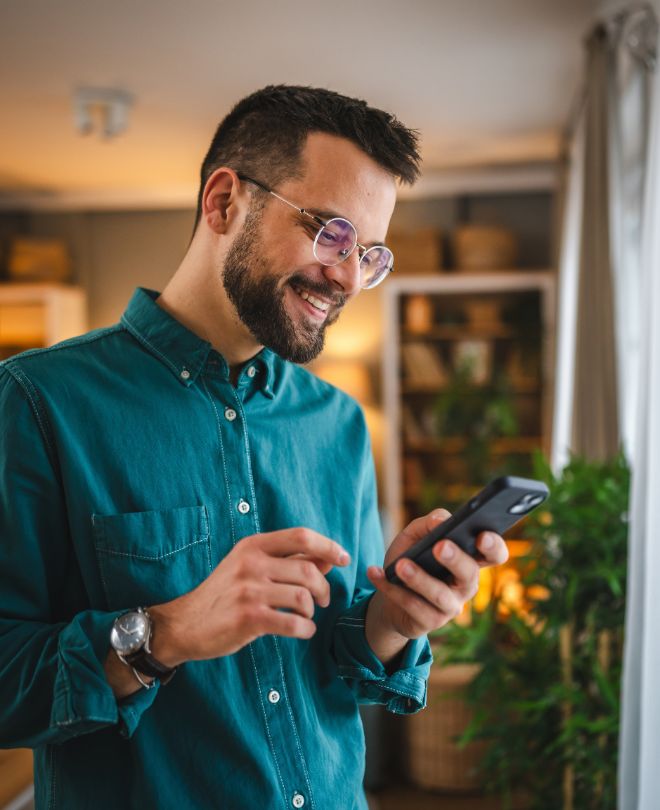 Un hombre usando su teléfono alegremente