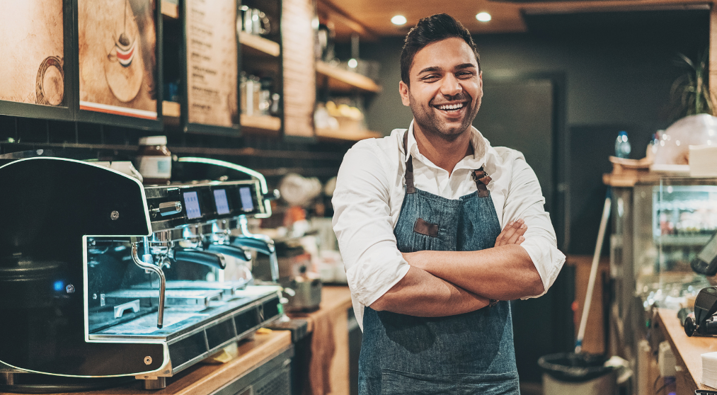 Laughing man behind bar.
