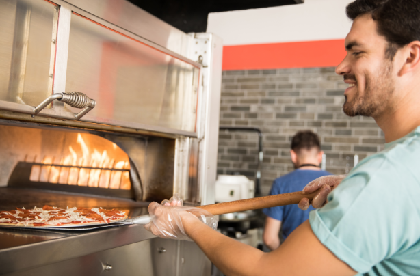 Man using a commercial pizza oven