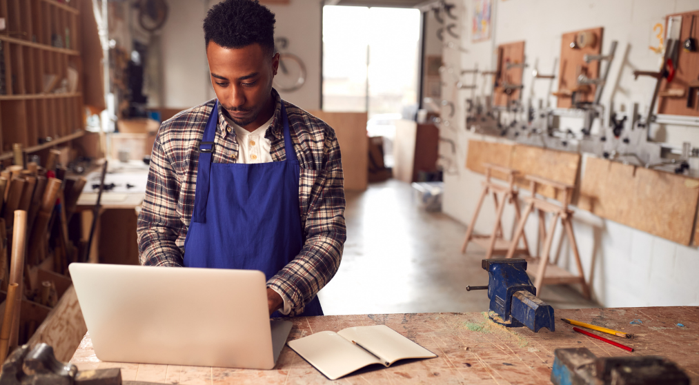 Man in workshop using laptop.