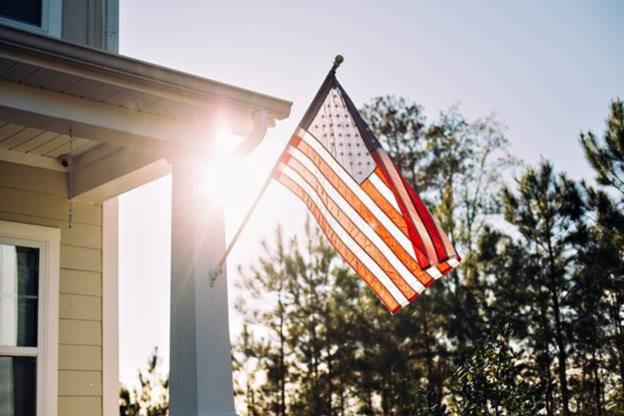 US flag on the font porch with the sun shining through